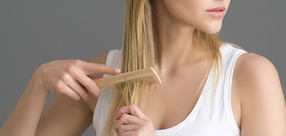 women combing hair with wood comb